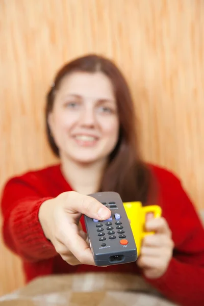 stock image Girl changing channels with clicker at home