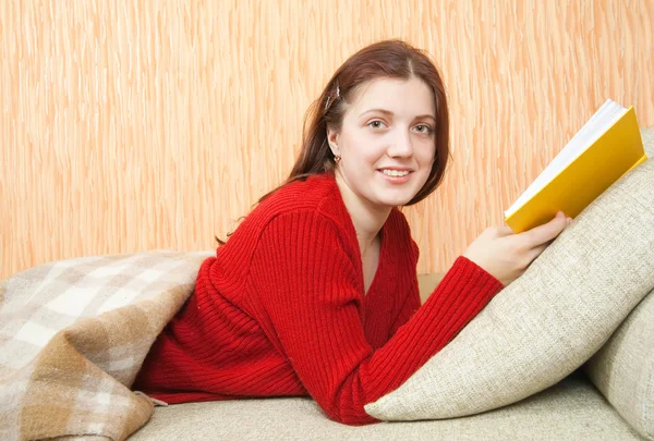 年轻漂亮的姑娘读本书在沙发上 — 图库照片