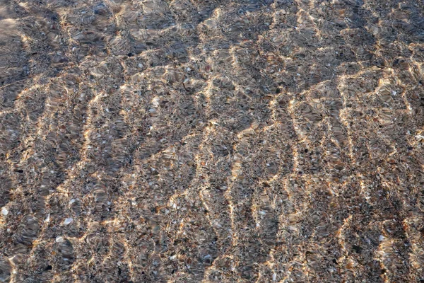 Primer plano del agua ondulada en la arena — Foto de Stock