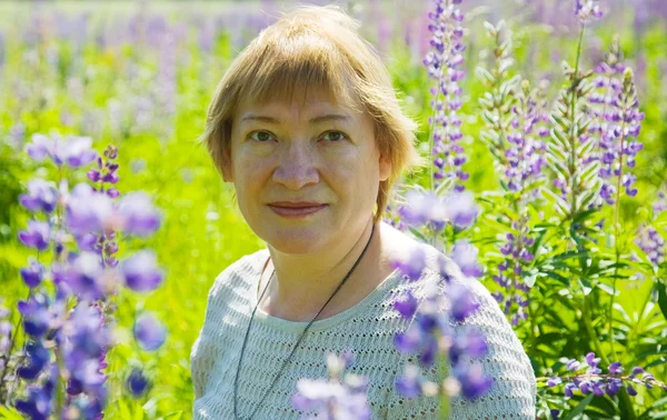 Женщина в растении фиолетового дикого люпина — стоковое фото