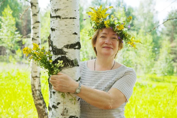 Vrouw in de buurt van berken in bloemen krans — Stockfoto