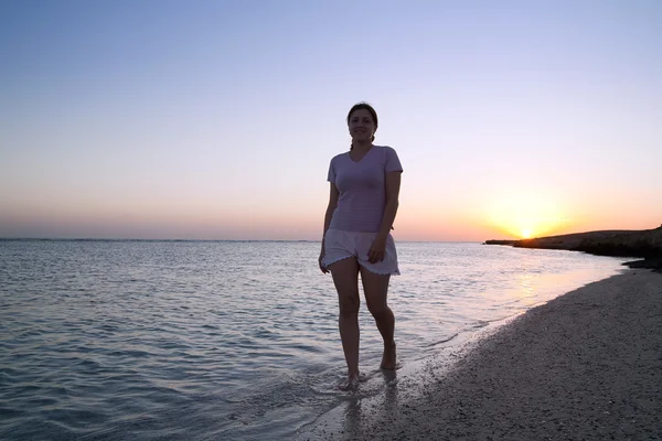 Meisje op zee Golf tijdens zonsondergang van een zon — Stockfoto