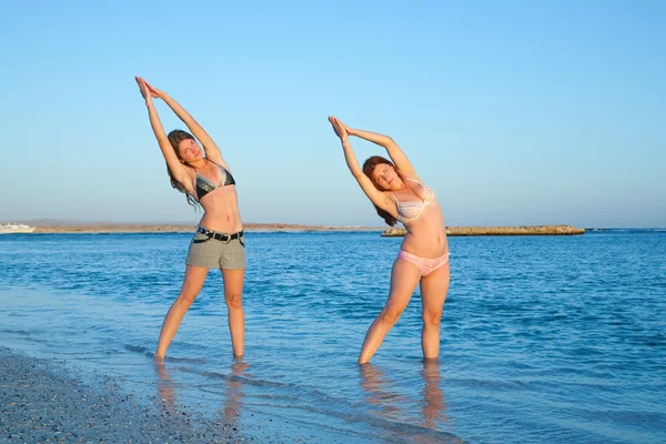 Dziewczyny robienie yoga z morza — Zdjęcie stockowe