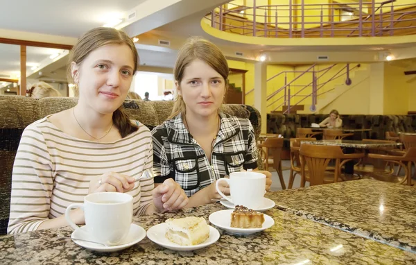 Красивые девушки расслабляются в кофейне с чашкой чая — стоковое фото