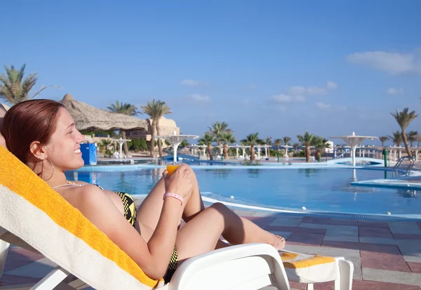 Dívka relaxační s pomerančovým džusem resort Hotel — Stock fotografie