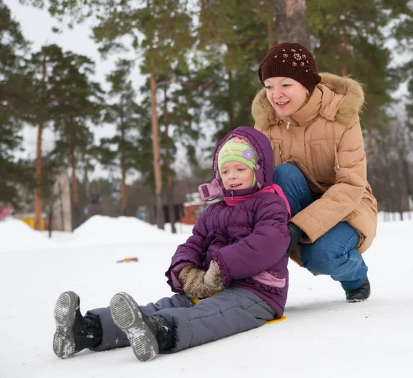 Gyermek a hóban vele anya csúszó — Stock Fotó