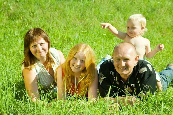 Famille heureuse posée sur l'herbe — Photo