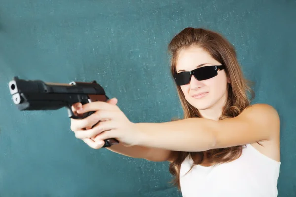 Meisje, pogend een zwarte pistool — Stockfoto