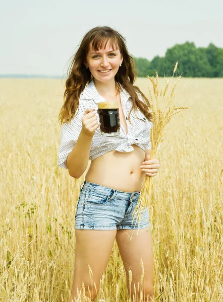 Девушка с пивом на поле — стоковое фото