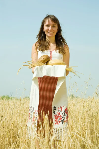 Meisje met brood op veld — Stockfoto