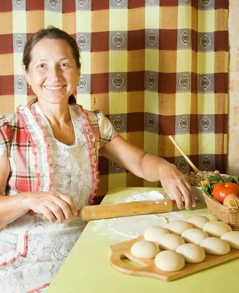 Woman cooking with rolling pin — Stock Photo, Image