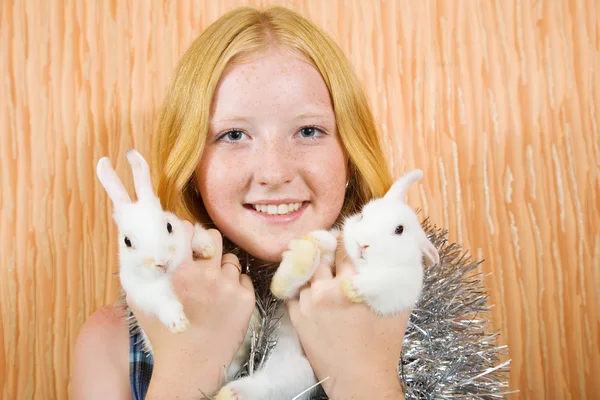 Girl in tinsel with two pet rabbits — Stock Photo, Image