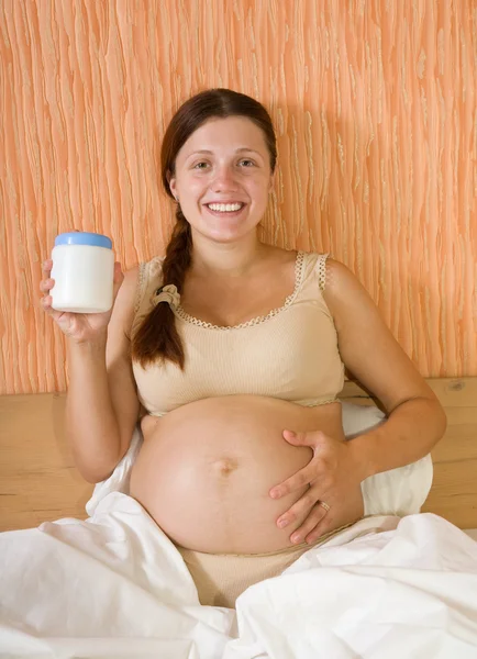Mulher grávida com creme corporal — Fotografia de Stock
