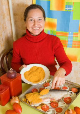 Woman is making breaded fish clipart