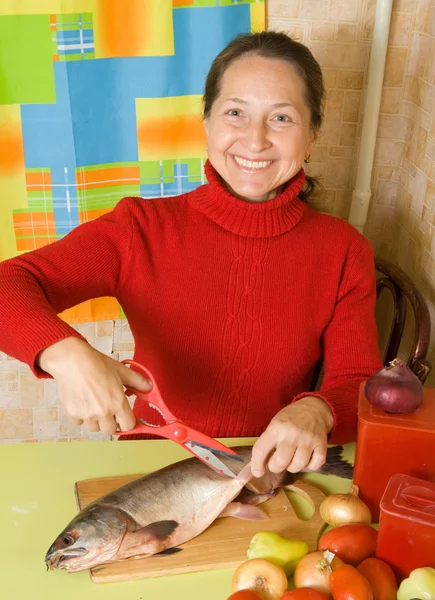 Vrouw snijden flippers met een schaar — Stockfoto