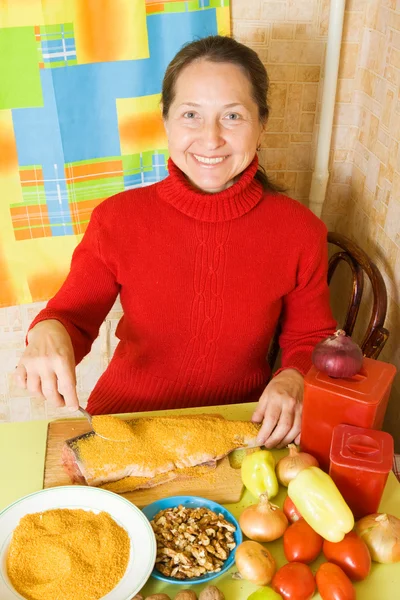 Woman is breading red fish — Stock Photo, Image
