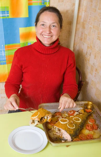 Mulher cortando peixe empanado — Fotografia de Stock