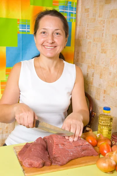 Mature woman is cooking beef — Stock Photo, Image