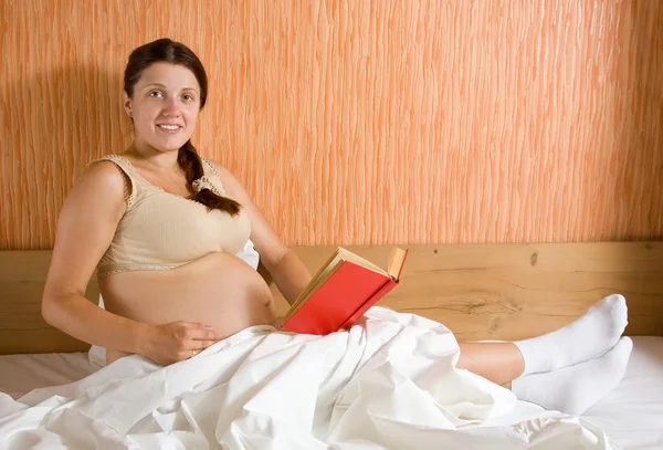 Těhotná žena čtení kniha — Stock fotografie