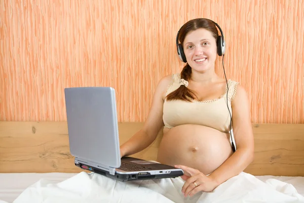 Donna incinta felice con computer portatile — Foto Stock