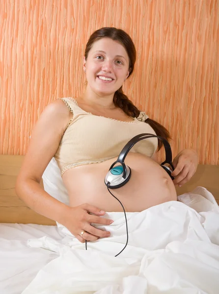 妊娠中の女性の音楽を聴く — ストック写真