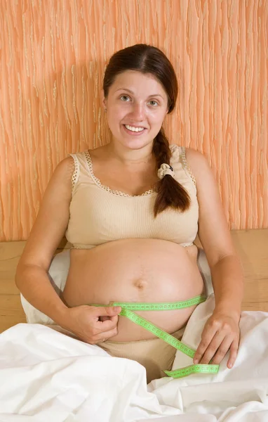 Беременная женщина, измеряющая живот — стоковое фото