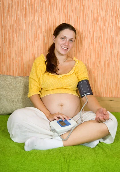 Mulher grávida com tonômetro em casa — Fotografia de Stock