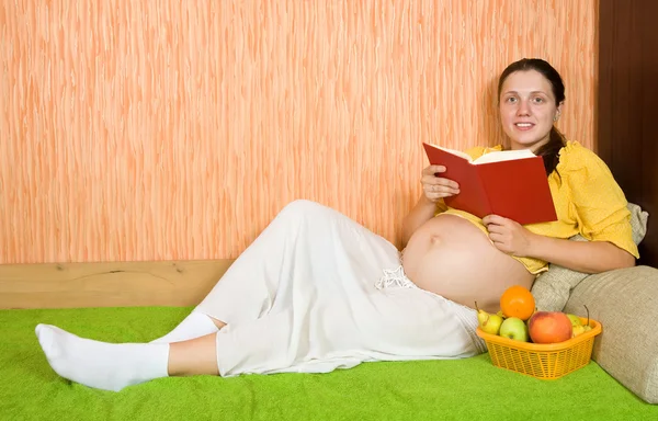 妊娠中の女性がソファに横たわっています。 — ストック写真