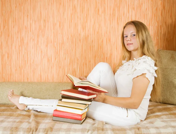 Dívka čtení knih na pohovce — Stock fotografie