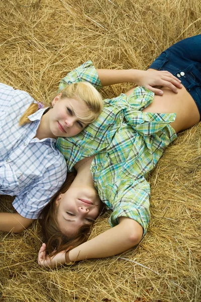 Country girls restings on hay — Stock Photo, Image
