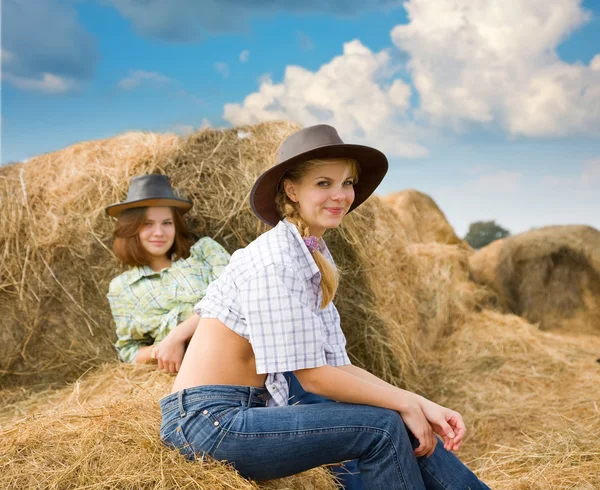 Farm girls restings on hay — Stock Photo, Image