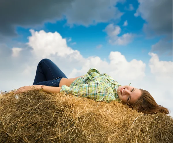 Дівчина відпочиває на солом'яному тюку — стокове фото