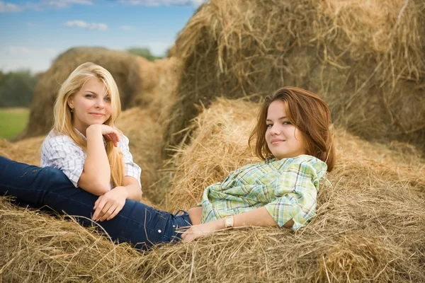 Farm girls on hay — Stock Photo, Image