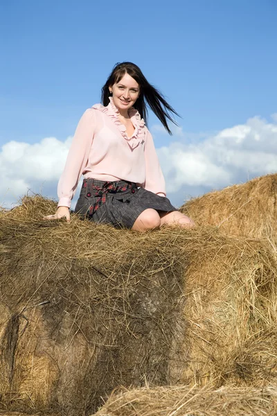Meisje in ingecheckte shirt rustend op hooi — Stockfoto