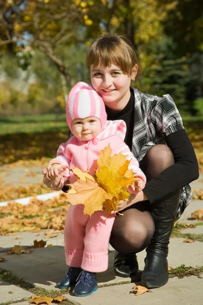 Mãe com bebê contra a natureza do outono — Fotografia de Stock
