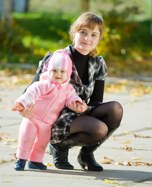 Moeder met baby tegen herfst — Stockfoto