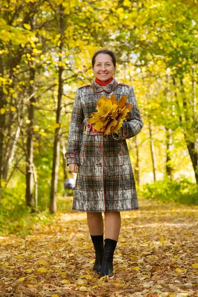 Mujer mayor caminando en el parque de otoño —  Fotos de Stock
