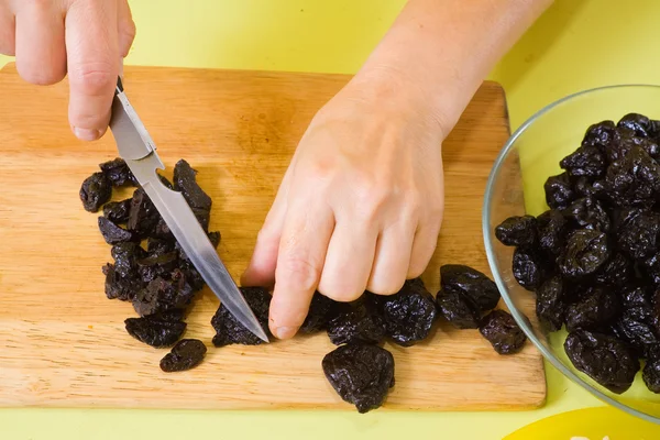 Las manos de cocinero están cortando ciruelas pasas — Foto de Stock