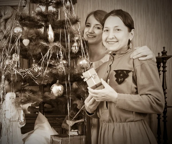 Retro photo of daughter with mother near Christmas tree — Stock Photo, Image