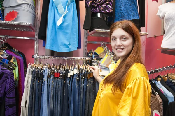 Kvinna shopping hennes kläder i tyg butik — Stockfoto