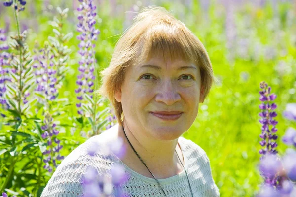 Woman in plant of violet wild lupine — Stock Photo, Image