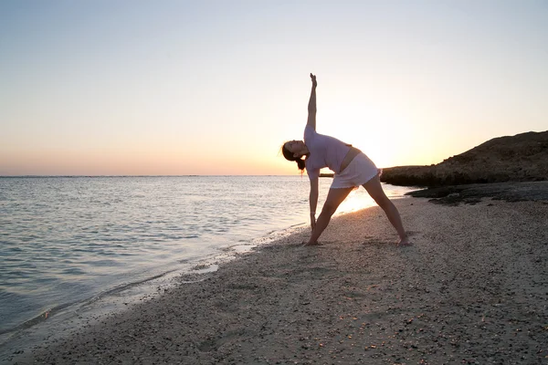 Дівчина робить йогу проти заходу сонця — стокове фото