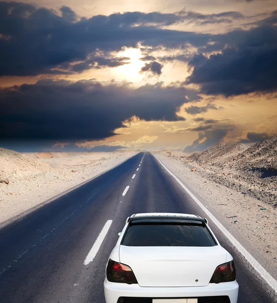 Білий автомобіль на пустельній дорозі — стокове фото