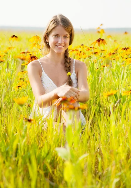 Flicka sitter i blommor — Stockfoto