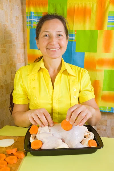 Vrouw wordt toegevoegd wortel aan kip — Stockfoto