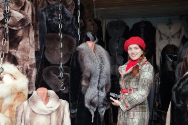 Woman chooses fur coat clipart