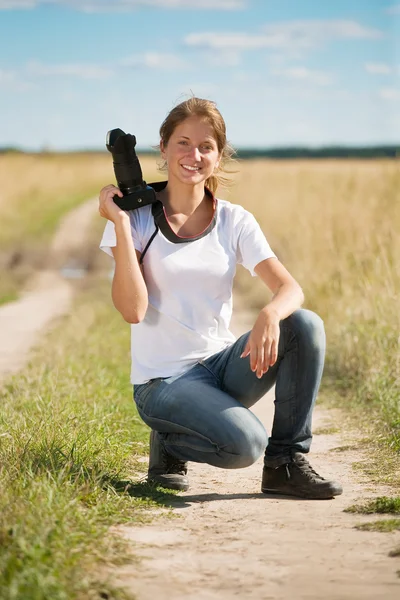 Girl with photocamera at field — Stock Photo, Image