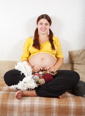 Pregnant woman knitting with knitting-needle clipart