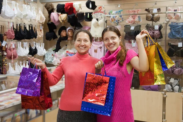 Две Счастливые Женщины Сумками Против Прилавка Магазине Нижнего Белья — стоковое фото
