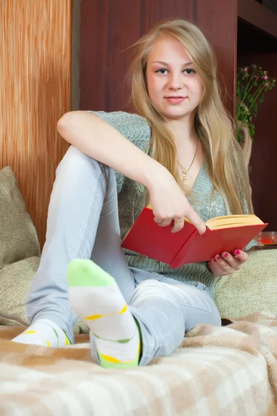 Meisje leesboek op sofa — Stockfoto